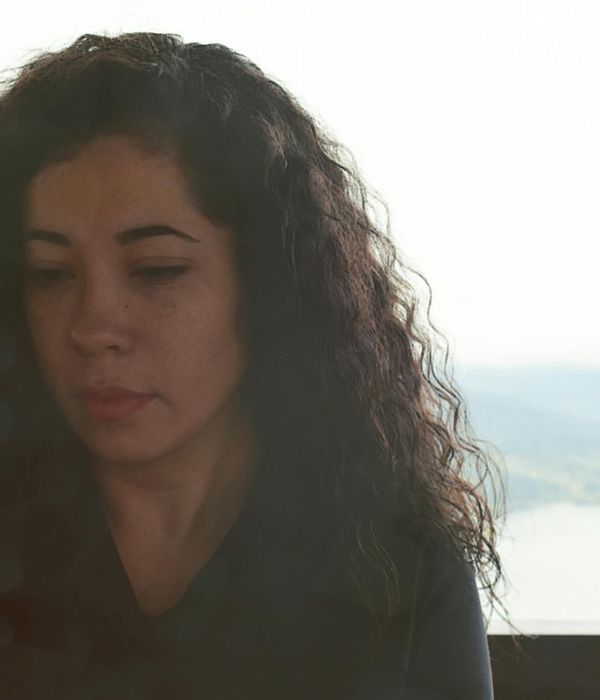 Person meditating outdoors with a serene landscape background.